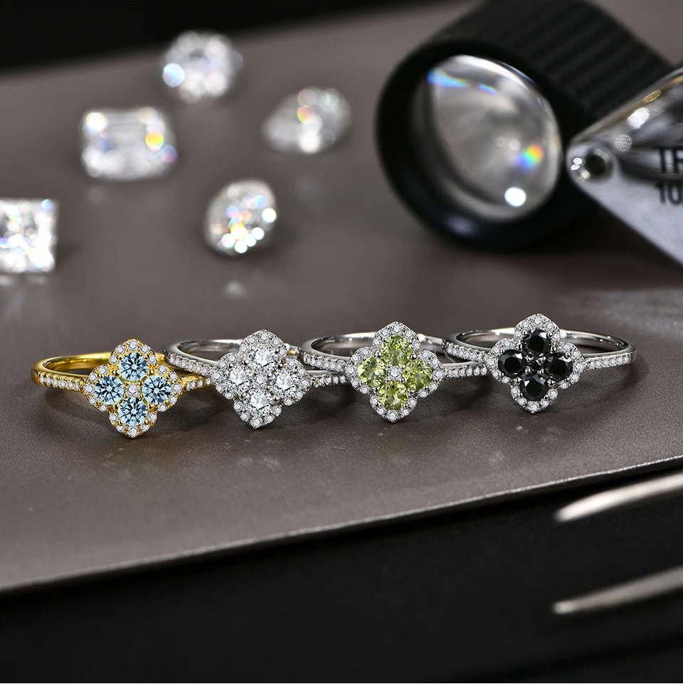 Four diamond rings with different colored gemstones on a dark surface from mirrorquenn jewelry store
