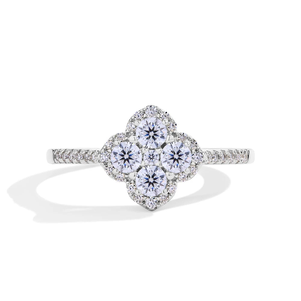 Diamond ring with floral design on a white background, branded with Mirrorquenn