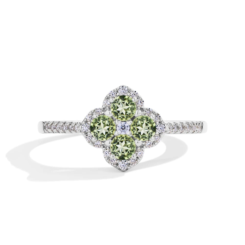 Green gemstone ring with diamond accents on a white background, branded with Mirrorquenn