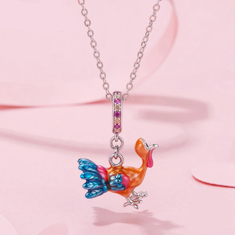 Colorful bird-shaped pendant on a chain with 'mirrorquenn' branding on a pink background