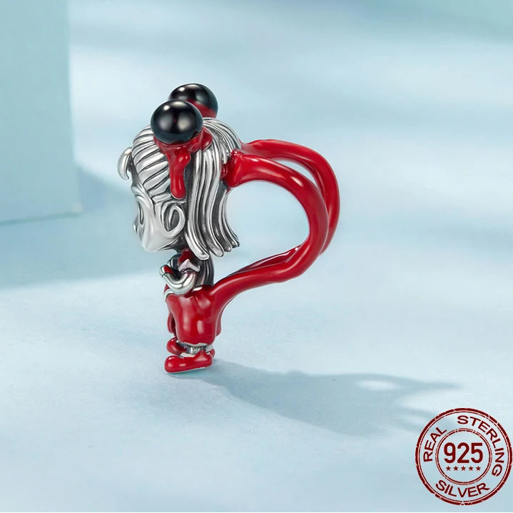 Silver and red charm with black bead on a light blue background, featuring mirrorquenn branding.