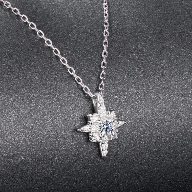 Silver necklace with a star-shaped pendant on a dark gray background